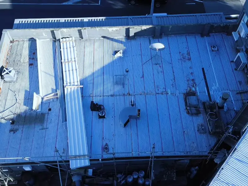 Before and after of a rusted roof replaced with new longrun steel